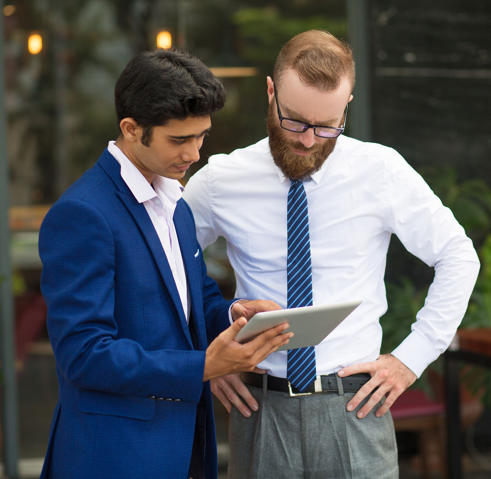 Businessmen with Tablet | CAQA LLND Two businessmen review data on a tablet, demonstrating employability skills training.
