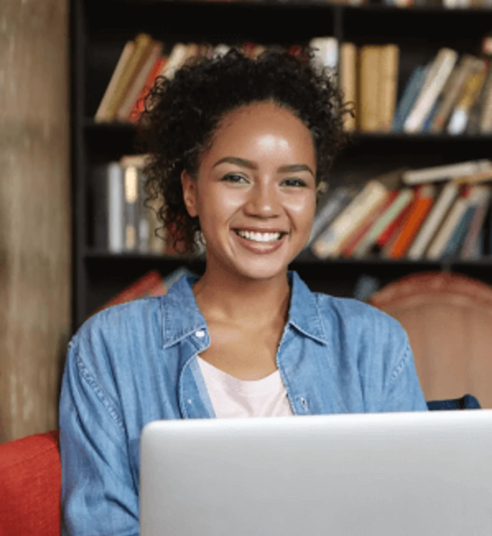 Smiling Woman | CAQA LLND A woman celebrates successful LLND assessment results while working on a laptop.