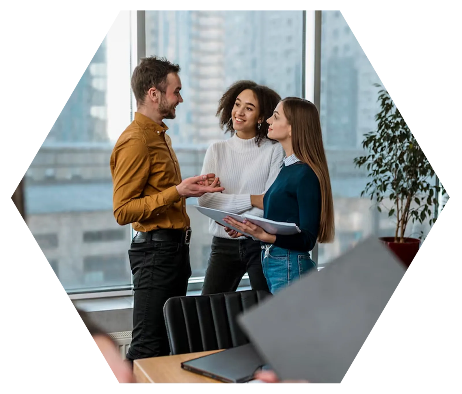 Team Collaboration | CAQA LLND Three colleagues discuss documents in a modern office, demonstrating CAQA LLND's approach to resource development.