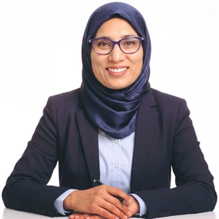Jasmeet Chahal | CAQA LLND A professional Muslim woman, Jasmeet Chahal, smiles for a portrait as part of the CAQA LLND team.
