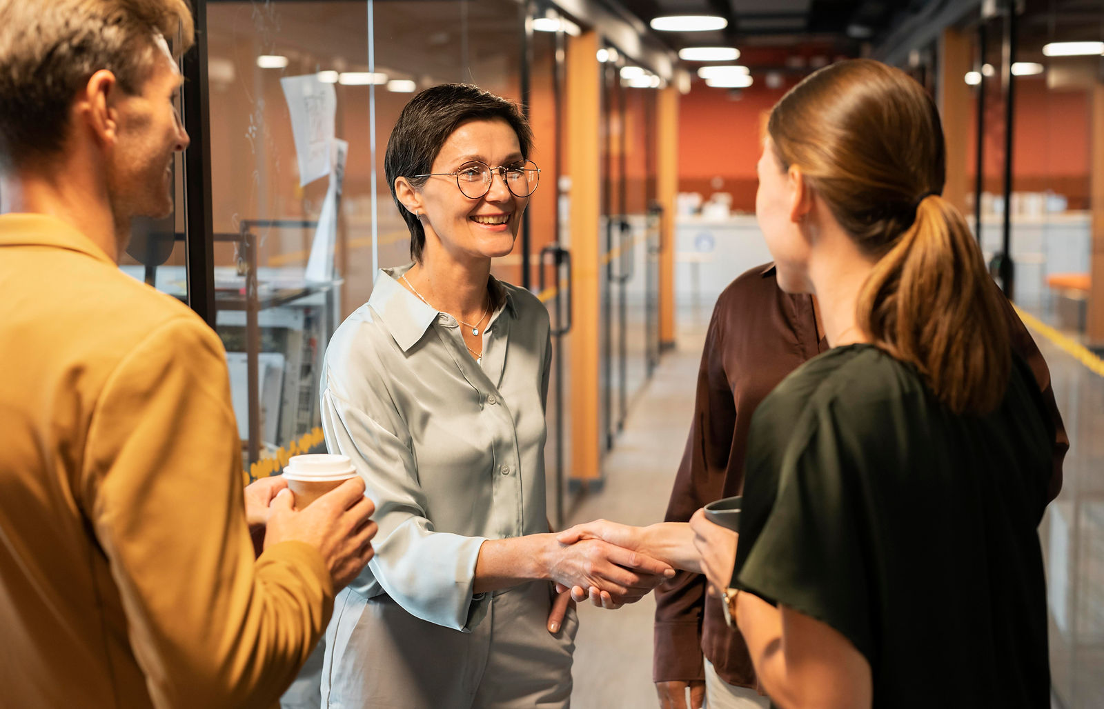 Women Shaking Hands | CAQA LLND Business professionals shake hands, demonstrating positive workplace connections and employability skills.
